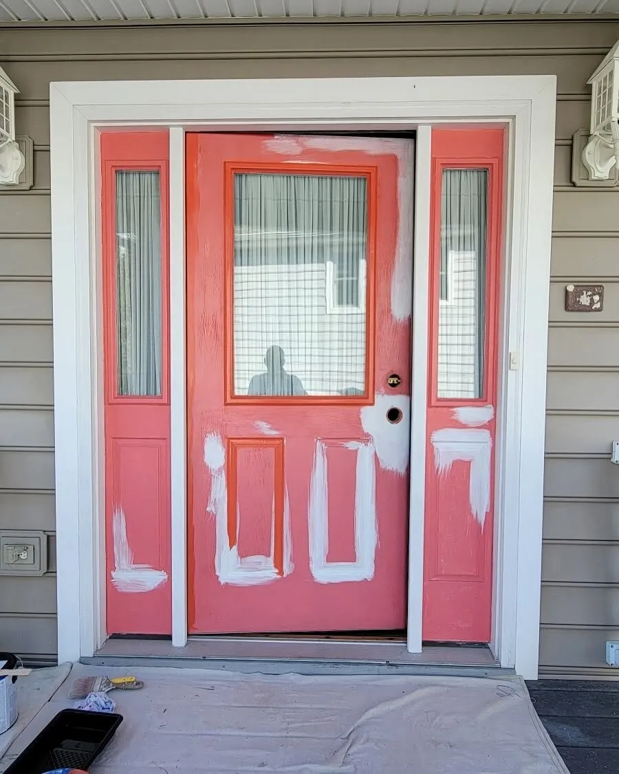 Before: front door mid-prep with patched, sanded areas and faded red paint