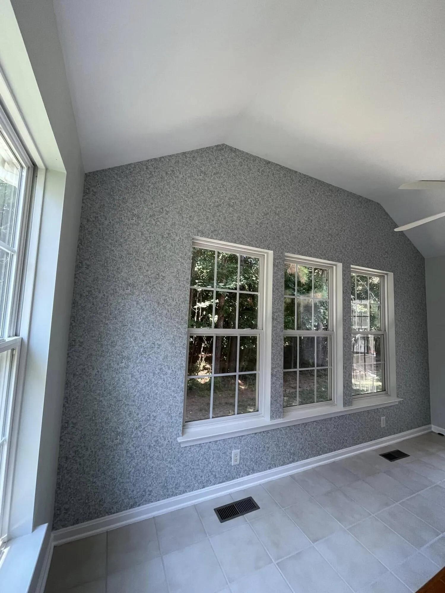 Sunroom walls covered in textured gray grasscloth wallpaper