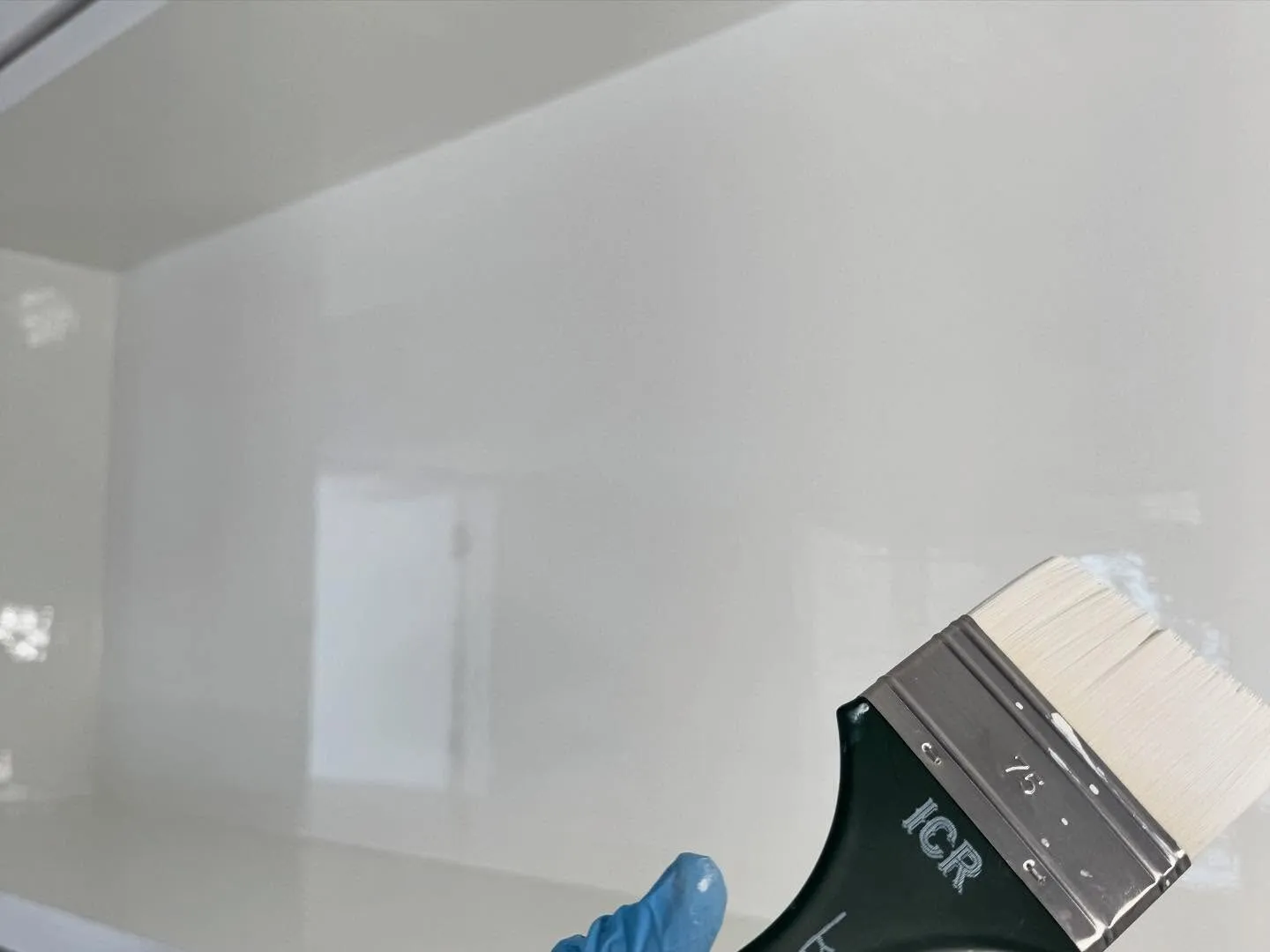 Brush laying down a glass-smooth high-gloss white finish
