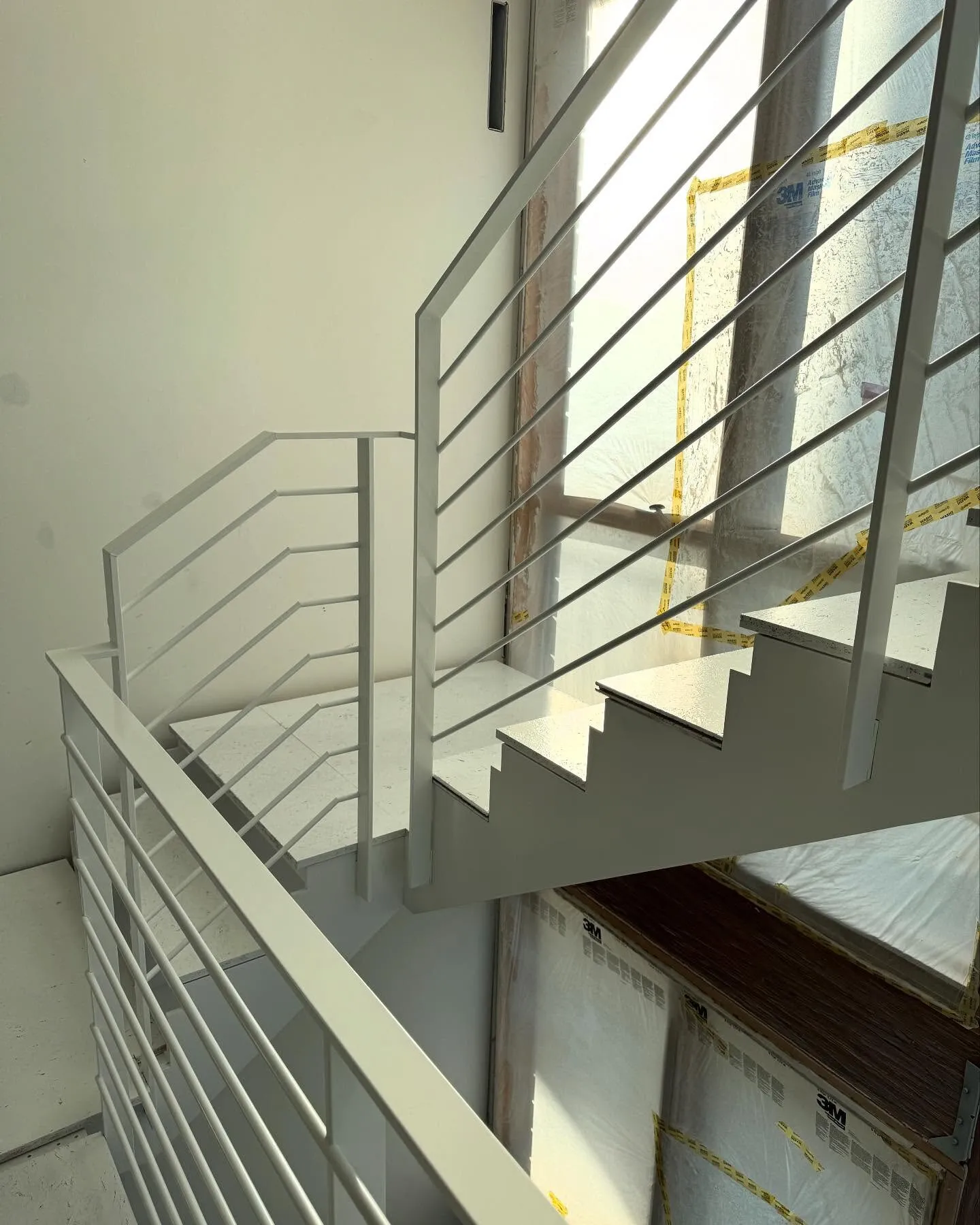 White painted metal stair railing in a modern stairwell