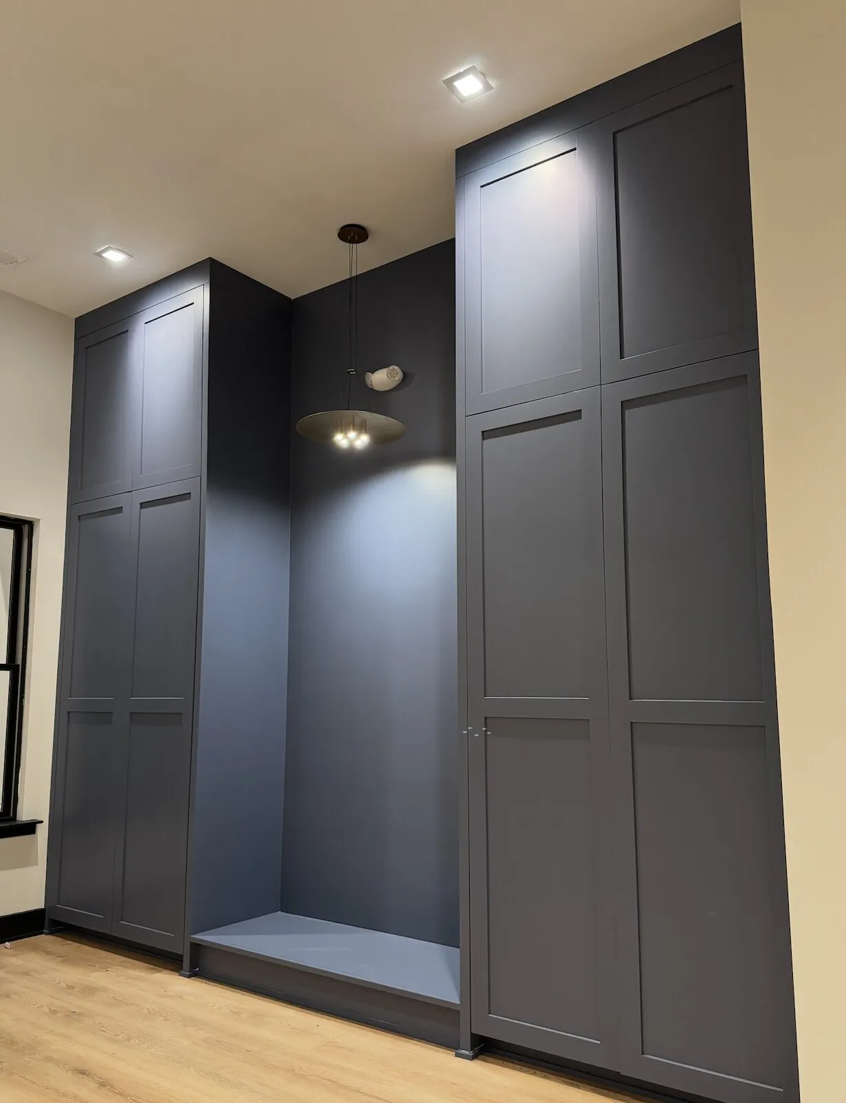 Floor-to-ceiling built-in cabinets painted deep navy with a smooth sprayed finish
