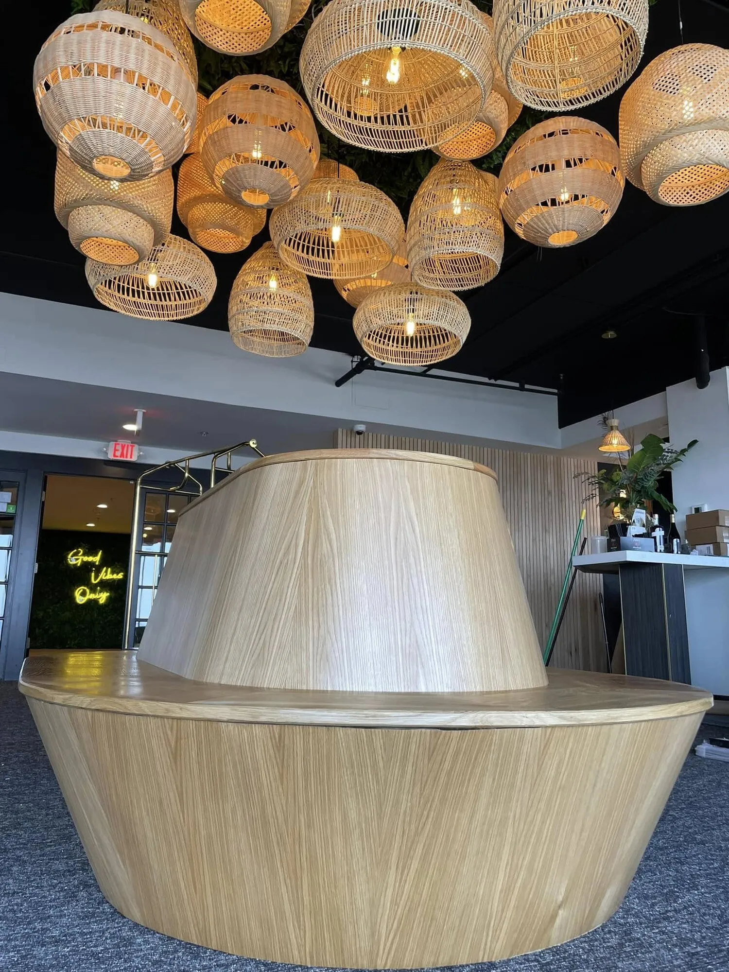 Finished round oak banquette beneath a cluster of rattan pendant lights