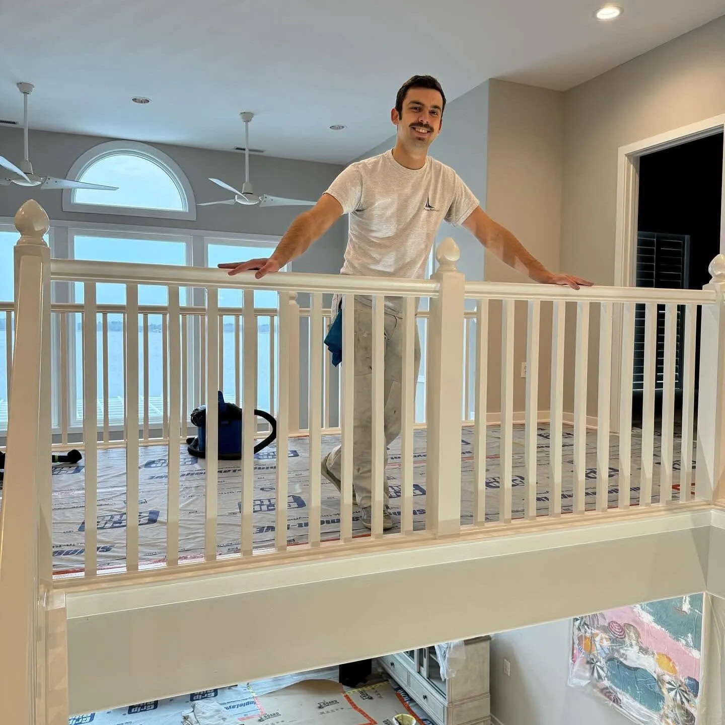 Tony LaBarck of Painter Tony smiling on a second-floor balcony during an interior painting job